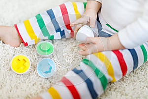 Close-up of baby playing playing with educational colorful shape sorter toy