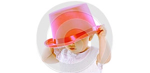 Close up baby puts on pink hat on a white background