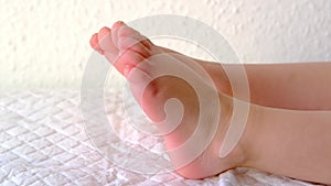 Close-up baby`s bare feet, child`s legs, health insurance, examination, treatment, preventive massage, strengthen musculoskeleta