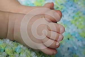 Close-up of Baby`s Feet on a Blue and Green Blanket
