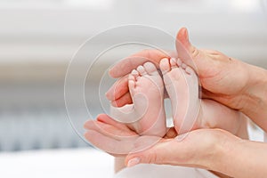 Close up of baby& x27;s foots in mother hands. Childhood and baby care concept