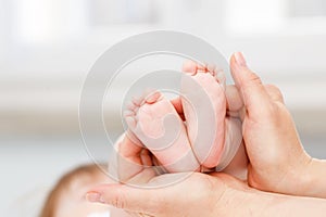 Close up of baby& x27;s foots in mother hands. Childhood and baby care concept