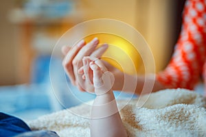 Close-up of baby`s hand holding mother