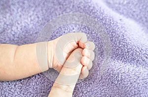 Close up, Baby`s hand holding a parent`s finger, symbolic of love, protection for a newborn.