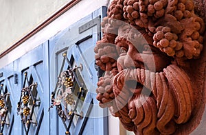 Close up of a Bacchus figure against blurred facade.