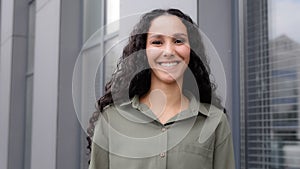 Close-up back view from behind dark curly long hair female hairstyle woman turn head turning to camera happy smiling