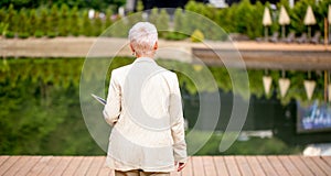 Close up back view photo of elegant woman strolling on the pavement