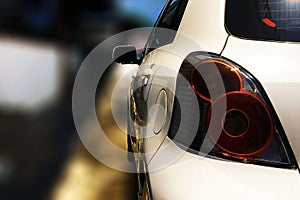 Close up back view of white car is outdoor with bokeh background