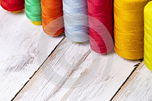 Close-up background of colorful vibrant silk threads on sewing s