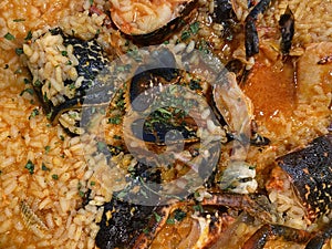 Close-up background of creamy rice with lobster, clams and other seafood. Spanish galician food