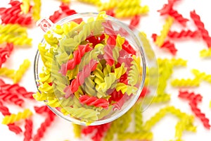 Close-up background of Fusille and Rotini in a glass bowl on white. pasta