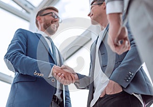 Close up. background image of a business handshake in the office lobby.