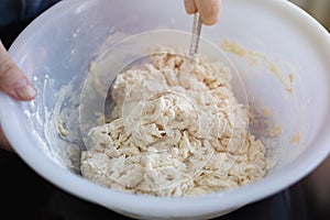 Close up background of kneading dough in bowl for bread, pasta or pizza on black table
