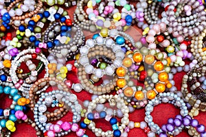 A close-up background of numerous bracelets made of colorful beads