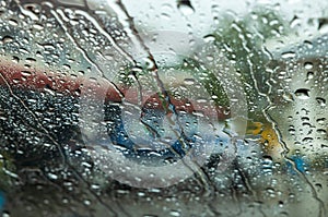 Close-up background view of many rain drops flowing outside the front windshield