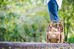 Close up backpack of woman backpacker standing on countryside road with tree in spring green seasonal,Alone travel or single