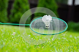 Close up Badminton racket and shuttle on green grass backgroung, copy space