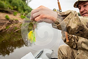 Close-up bait for fish on fishing spinnerbait yellow in the hands of the fisherman photo