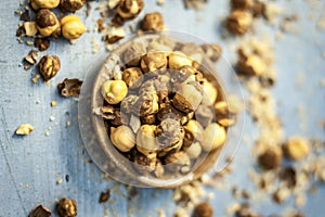 Close up of baked or roasted chickpea/channa or dalia in a bowl on a blue surface.