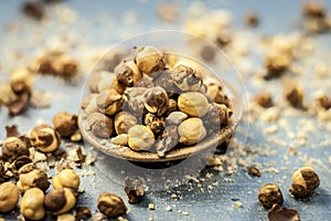 Close up of baked or roasted chickpea/channa or dalia in a bowl on a blue surface.