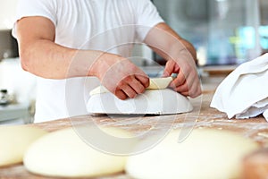 Close-up of the Baker`s hands. Preparation of flat cakes from yeast dough. The concept of baking or making fresh bread.