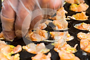 Close up baking prawns in baking pan with holes