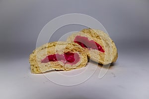 Close up of Bakpao or buns with red strawberry flavored jam inside and white background.