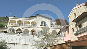 Close-up of balcony on luxury villa in resort town, zoom out. Establishing shot