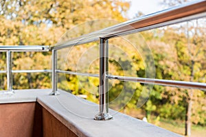 Close up of a balcony metal balustrade. Autumn view in the background. photo