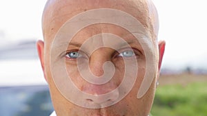 Close up of the bald man`s eyes looking into the camera. Close up shot.