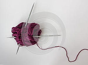 close-up of a ball of marsala yarn and two knitting needles