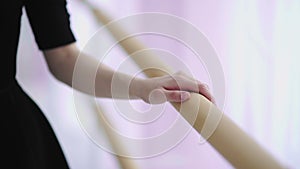 Close up of ballerinas hand on wooden barre