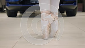 Close-up of ballet dancer`s feet, professional ballerina balancing on tiptoes and spinning. Car standing at the