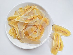 Close-up of banana chips or keripik pisang in a plate on a white background. photo