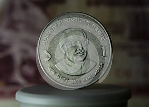 Close-up of a Bangladesh one taka coin against a dark background