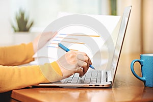 Close up banner of a woman using a laptop and financial graphs