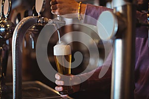 Close-up of bar tender filling beer from bar pump