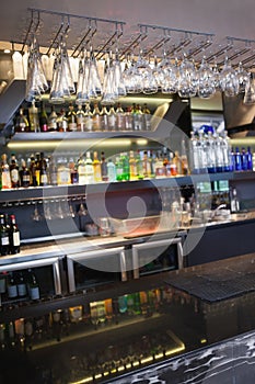 Close up on bar with wine glasses hanging above it