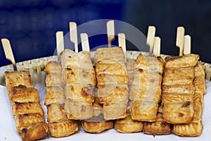 Close up of barbecue grill salmon skewers on wooden sticks, thai street food market