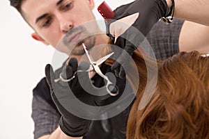 Close-up of barber trimming hair with scissors and comb