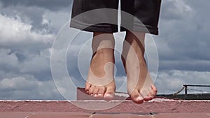 Close-up of bare feet of a little girl who is skipping rope