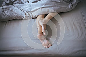 Close up of barefoot,Feet and stretch lazily on the bed after waking up at morning