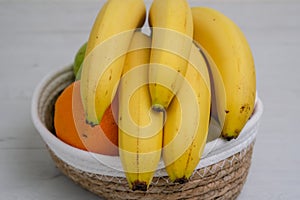 Close up of Barely ripe yellow bananas in natural wicker container