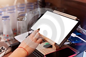 Close up of barista finger with manicure scrolling tablet pc at cafe, plane table with white blank screen, faceless waiter working