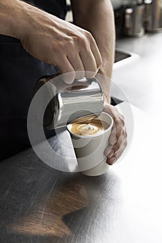 Close-Up of Barista Pouring Milk into Coffee Cup, Crafting Latte Art
