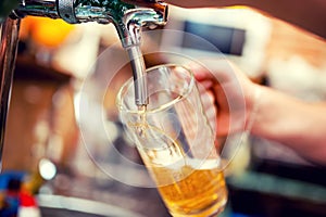 Close-up of barman hand at beer tap pouring a draught beer