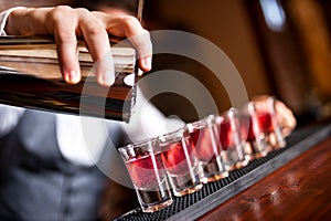 Close-up of barman hand pouring alcohol photo