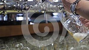 Close-up of barman hand pouring a lager beer