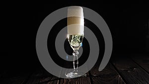 Close-up of the bartender pouring champagne into a glass on a black background.