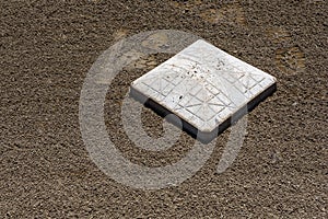 Close up of baseball base plate on a freshly groomed dirt field